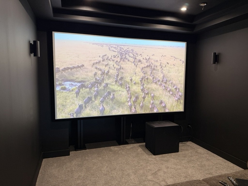 Dedicated home theater room with a 140-inch projection screen and surround speakers